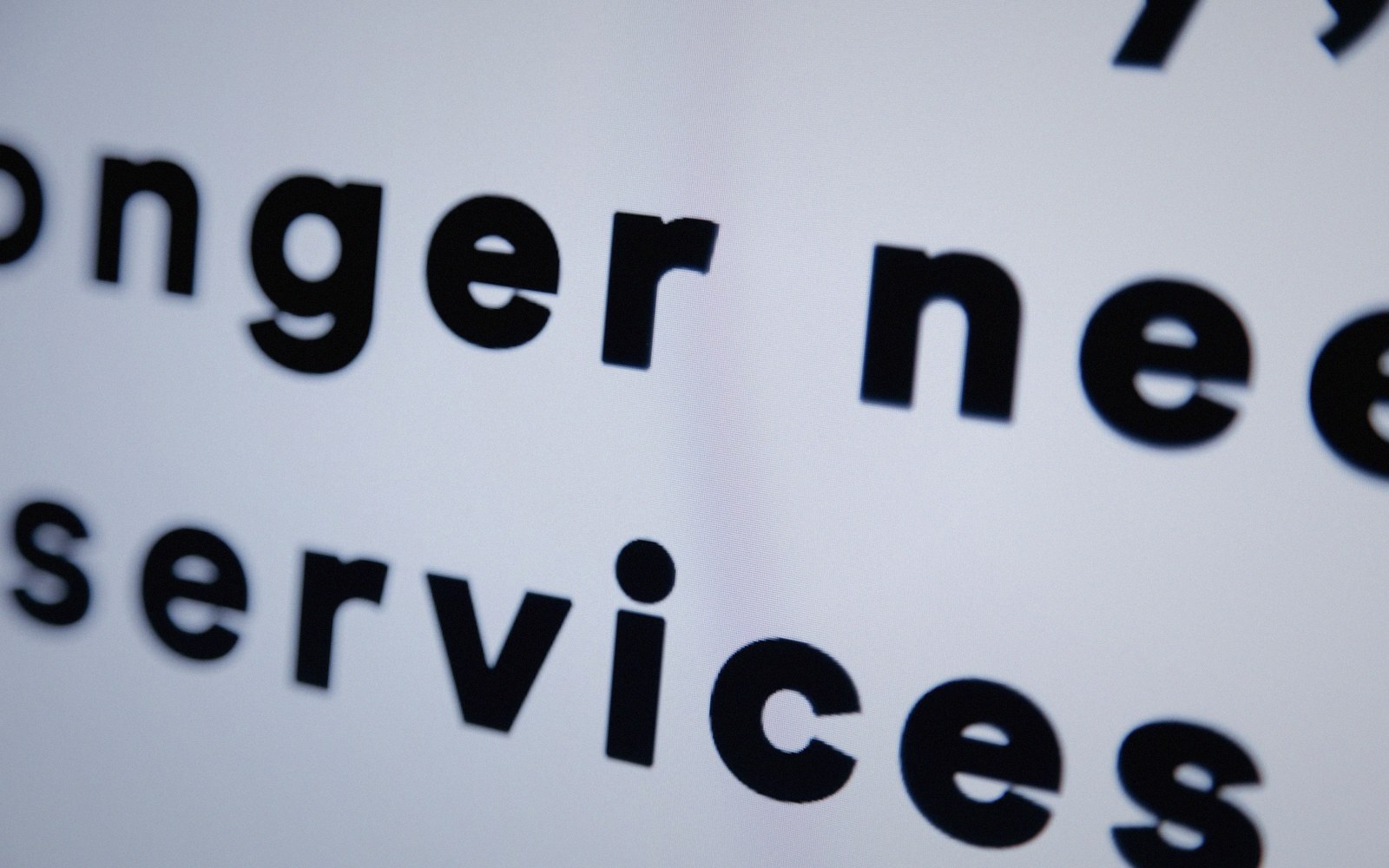 Close-up of printed text reading "longer needs" and "services" in bold black font